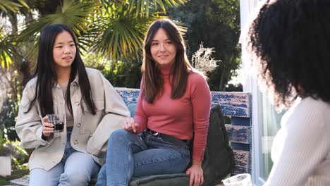 black woman talking with female friends in backyard on weekend party