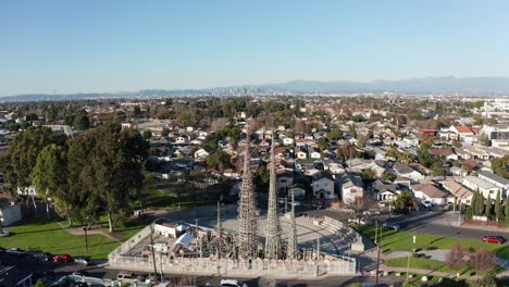 Close-up-panning-aerial-shot-of-the-Watts-Towers-with-downtown-Los-Angeles-in-the-background