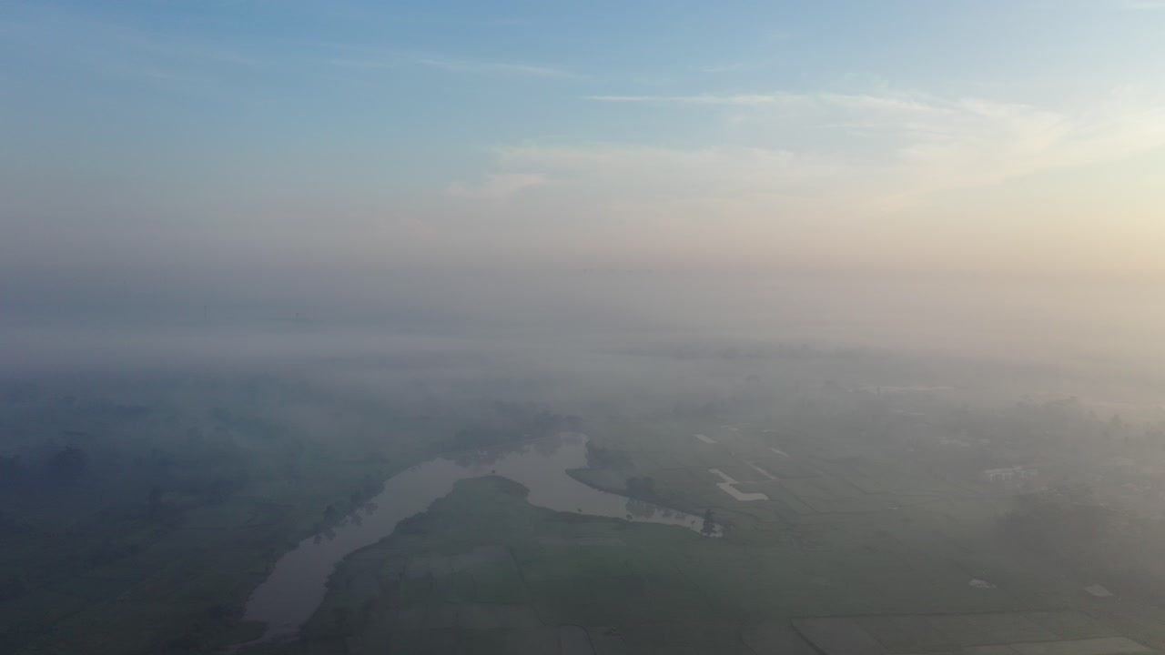vista aérea de un paisaje rural con un amanecer brumoso