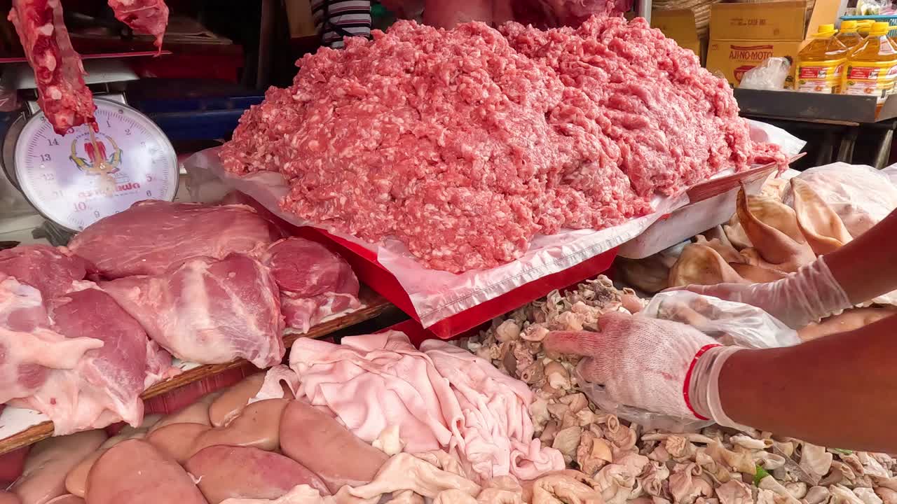 carnicero que arregla y pesa los cortes de carne fresca