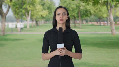 reportera de noticias india hablando con la cámara
