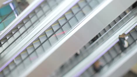 People-in-motion-in-escalators-at-the-modern-shopping-mall.-Tilt-shift-lens-shooting-with-super-shallow-depth-of-field.