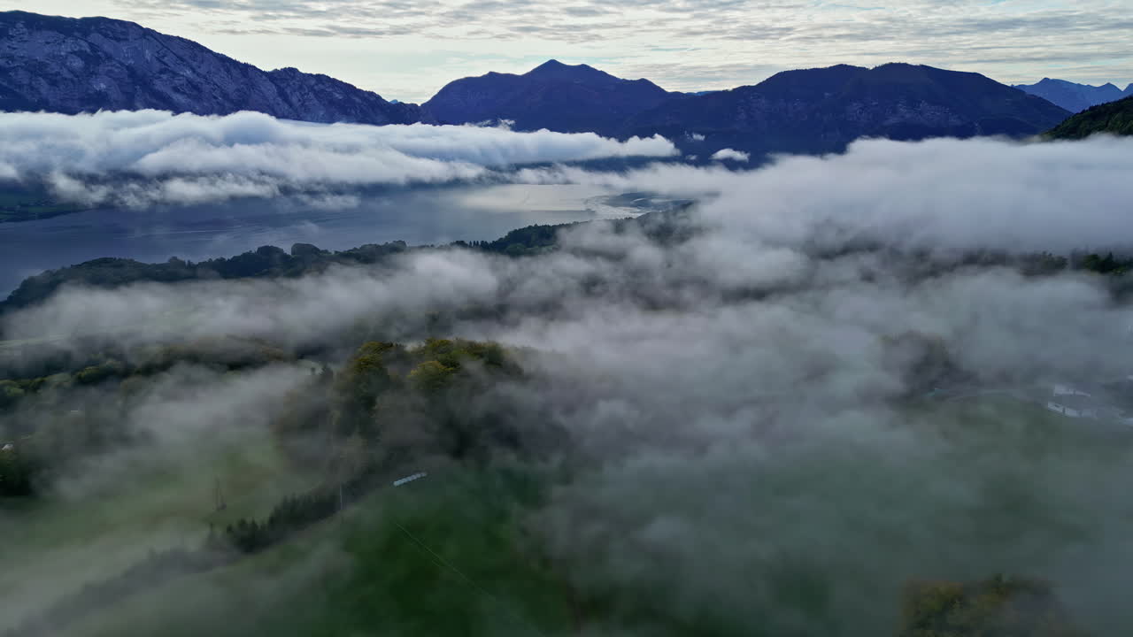 두꺼운 플로그는 숲의 나무 가노피와 호수 위에 있지만 노출된 산맥 아래에 있습니다.