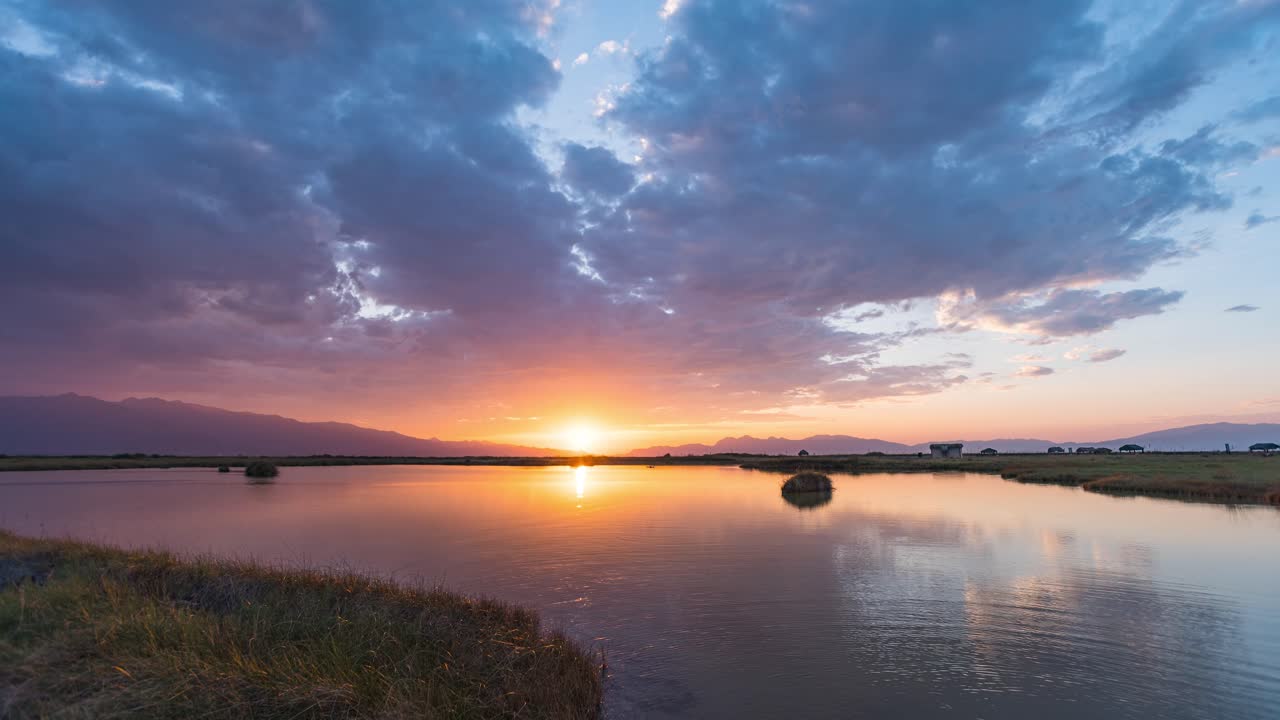Time lapse of Cuatro Ciénegas swamp ecological reserve during a cloudy golden hour and sunrise. Lake as mirror of the sky full of color. Coahuila, Mexico