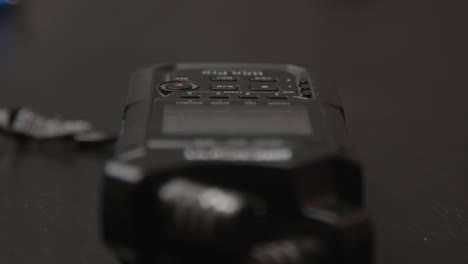 Close-up-of-finger-pressing-record-button-of-small-audiorecorder