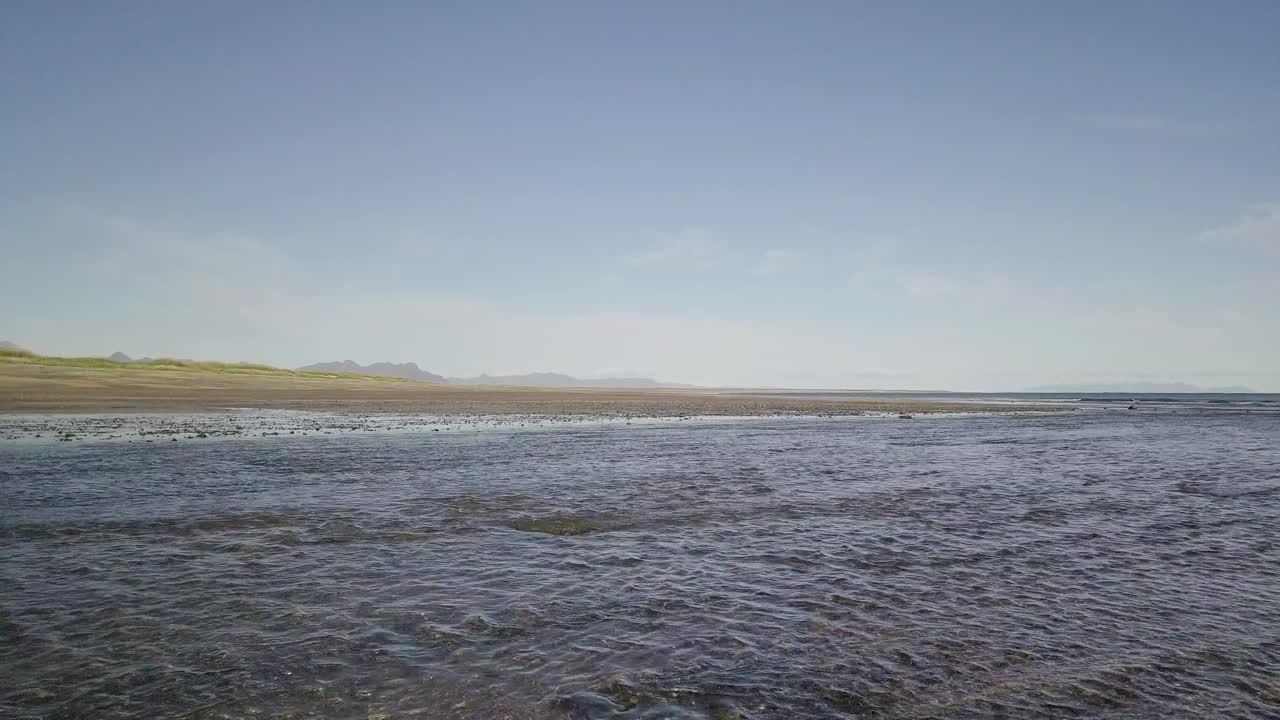 아이슬란드 스내펠스니스 반도에서 화창한 여름 동안 바위가 많은 해변과 바다 위로 저공비행