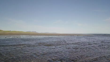 Low-Flight-Over-a-Rocky-Beach-and-the-Ocean-in-Sunshine-During-Sunny-Summer-In-Snaefellsness-Peninsula,-Iceland