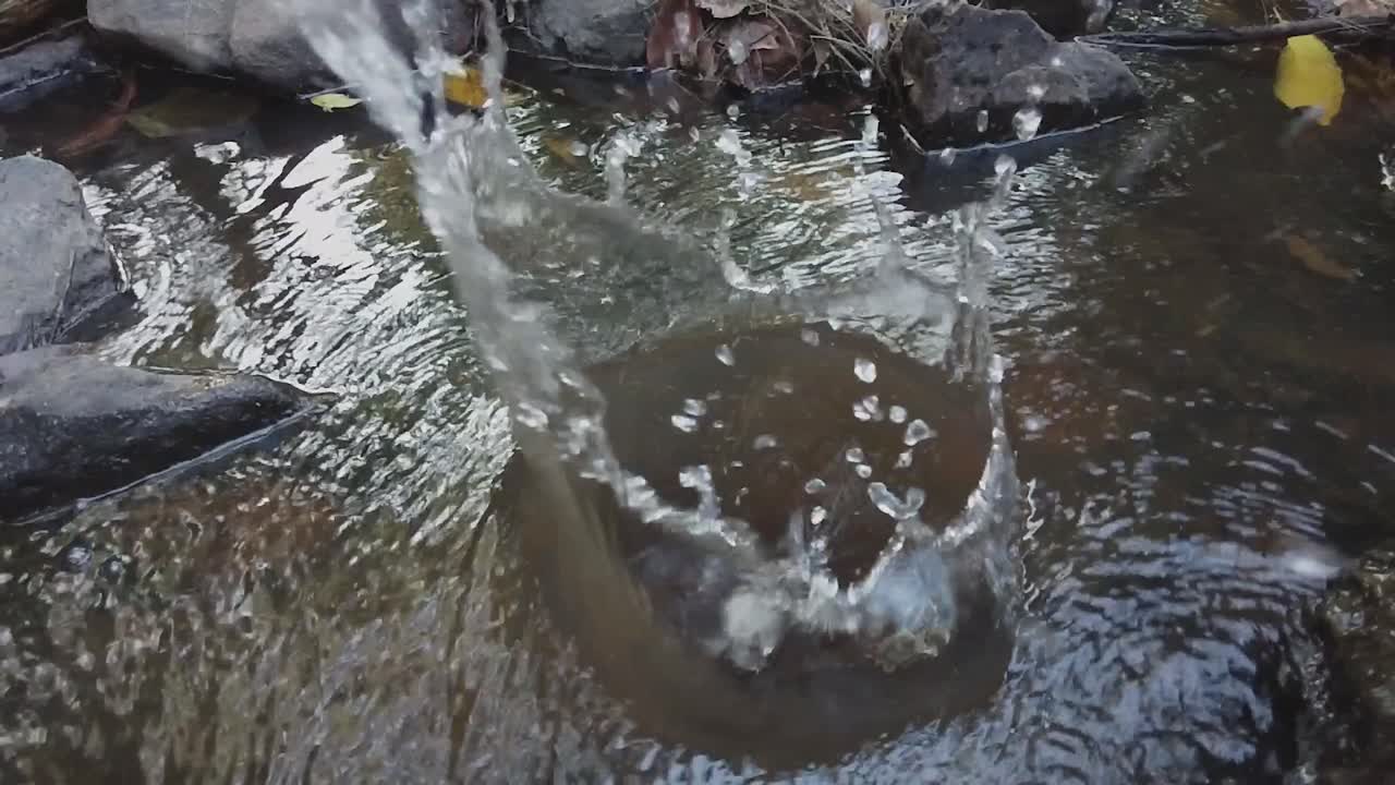 4K slow-motion footage of a rock thrown into a creek, creating a dramatic splash. Ideal for nature videos, action effects, or cinematic projects. Shot in H.264, 9s.License this dynamic stock footage!