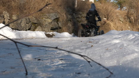 ATV-rides-past-tree-in-the-snow