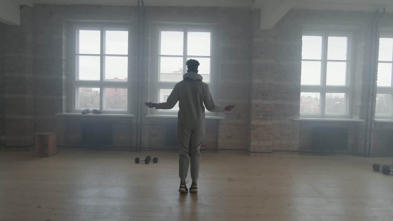 Man Jumping Rope In Smoky Loft