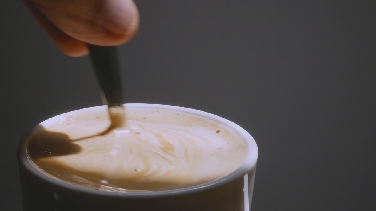 Barista making coffee. Cup of coffee. Coffee close-up. Stirring morning coffee.