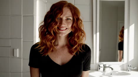 woman with red curly hair in a bathroom