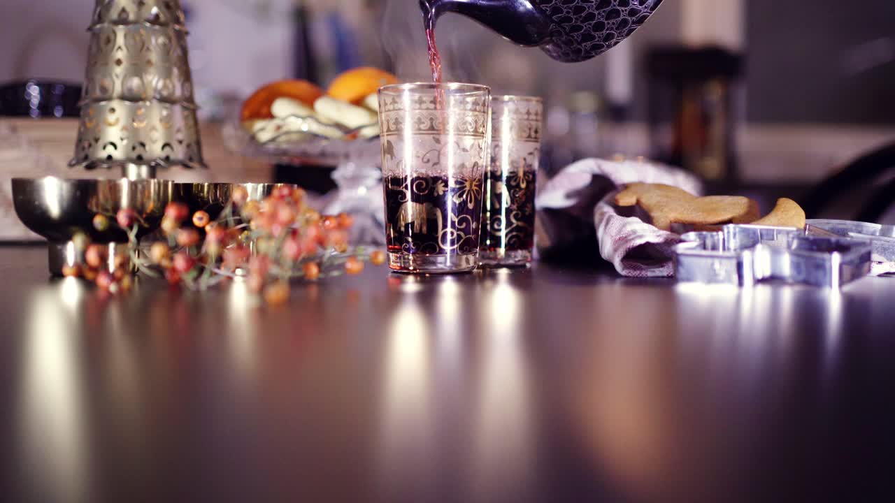 호스트는 축제 시즌을 축하하기 위해 장식용 잔에 멀드 와인을 붓습니다.