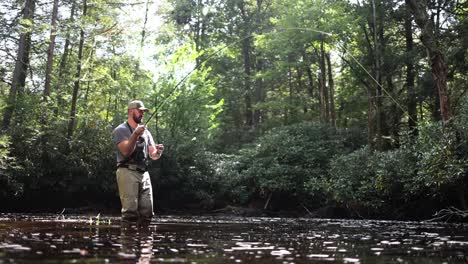 imágenes en cámara lenta a nivel del agua de un pescador de mosca en las montañas de pocono en pensilvania