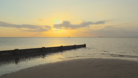 Barcos-Acercándose-Unos-A-Otros-En-El-Horizonte-En-El-Mar-En-Calma-Durante-La-Puesta-De-Sol-En-Cámara-Lenta-En-Fleetwood,-Lancashire,-Reino-Unido