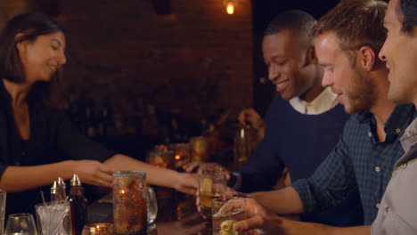 male friends enjoying night out at cocktail bar, slow motion