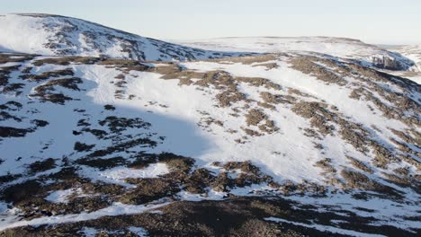 imágenes aéreas de drones que vuelan hacia un paisaje montañoso rocoso cubierto de nieve cerca de ben macdui en el parque nacional de cairngorms, escocia mientras el sol se refleja en la nieve y el hielo