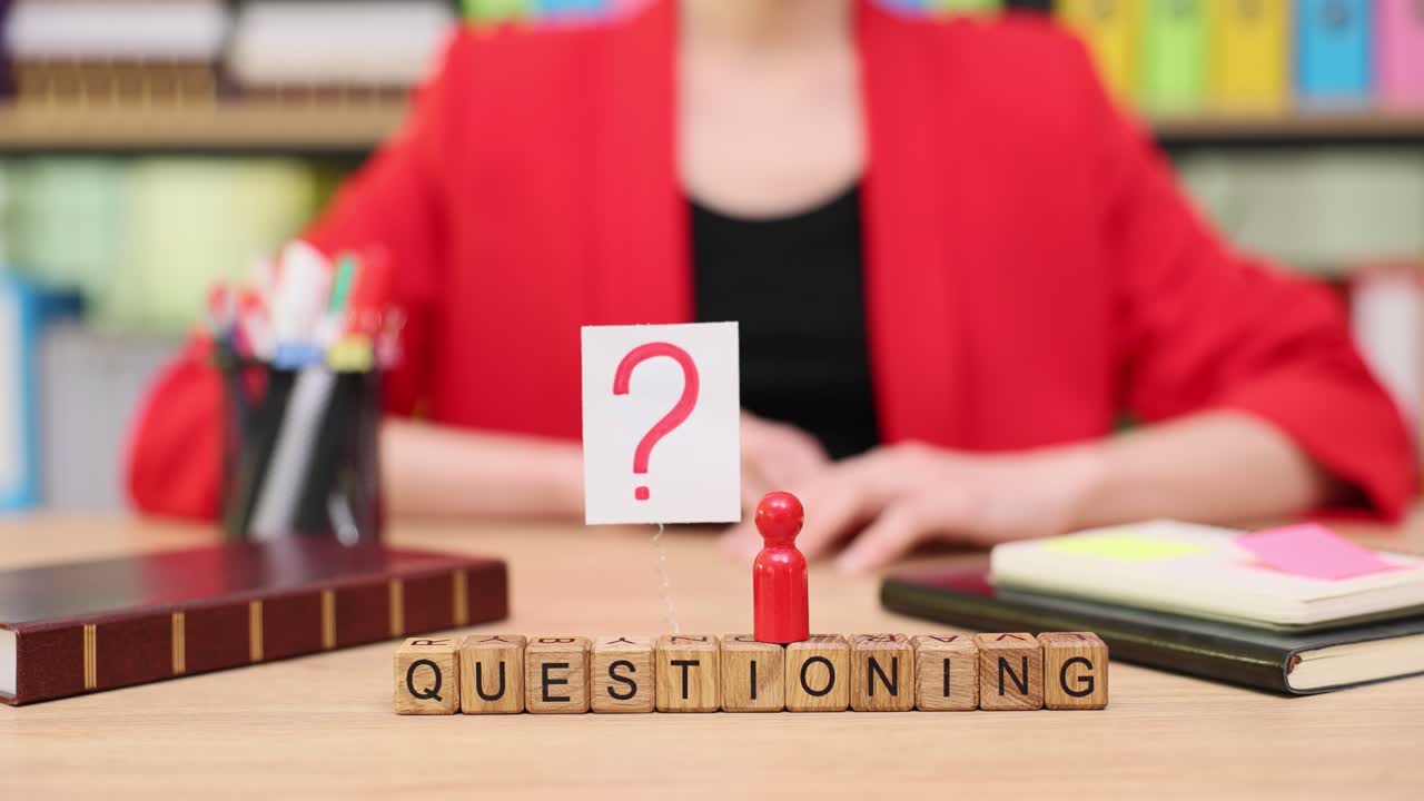 Businesswoman with Questioning Blocks and Question Mark