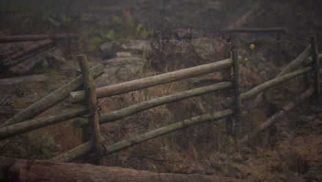 an old wood fence with a country field behind it