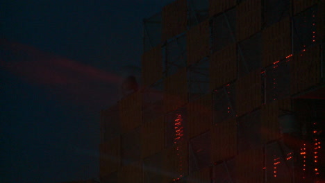abstract night time close up shot of moving head lights flashing and panning on a truss rig as part of a music festival stage.
