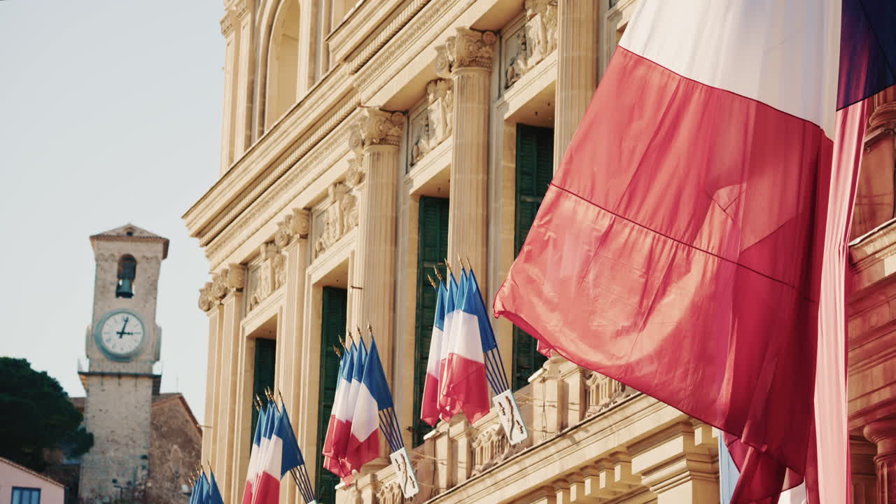 Campo lungo di un edificio storico decorato con bandiere tricolori francesi in una giornata limpida