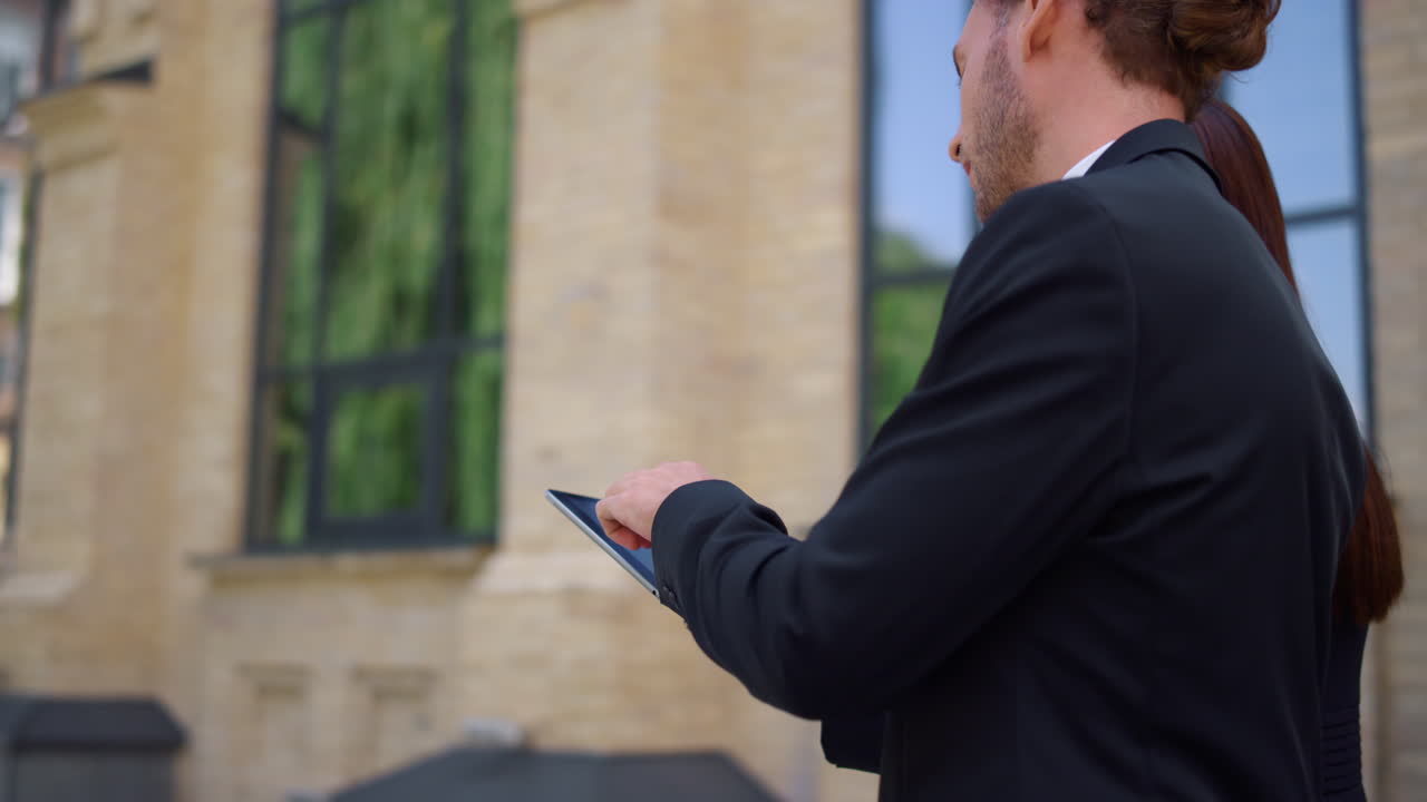 Business people looking tablet screen. Colleagues checking email while walking.