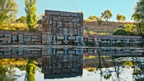 the peaceful ambiance of the holy water temple, reflecting its ancient stone carvings in the calm waters below