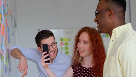 side view of young mixed-race business team planning and working on glass wall in modern office 4k