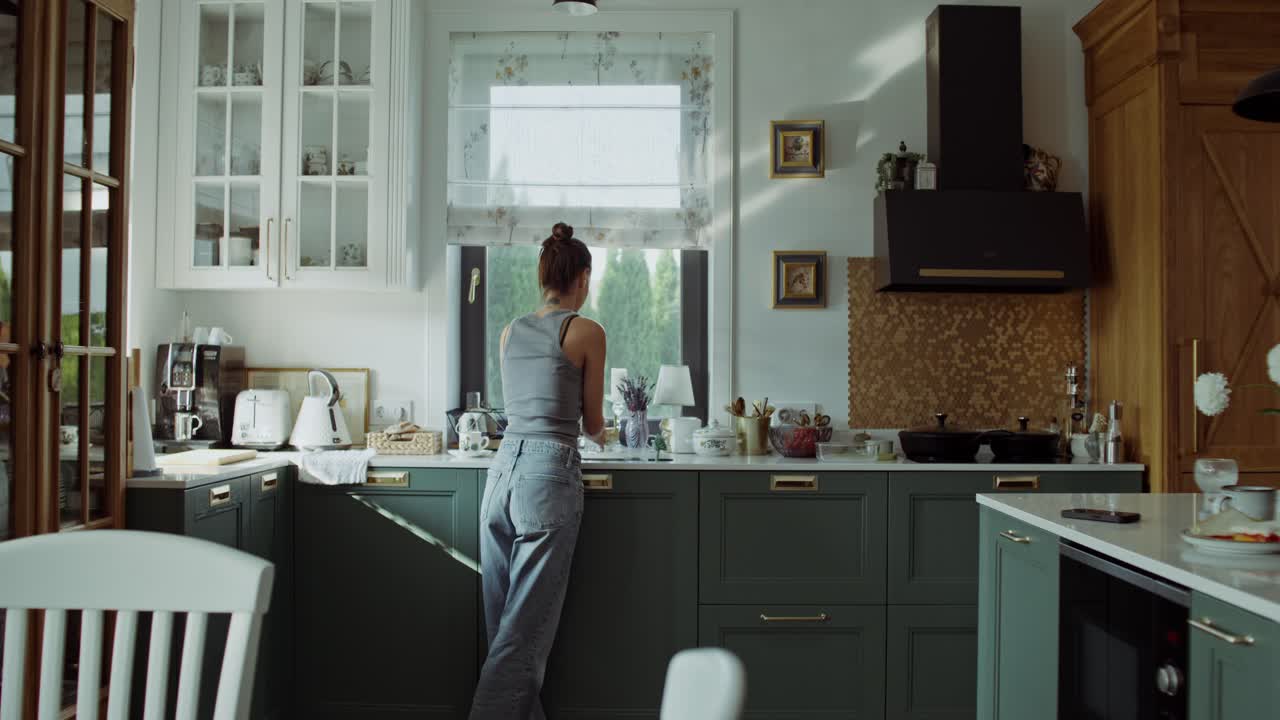 Donna che beve acqua in una cucina moderna