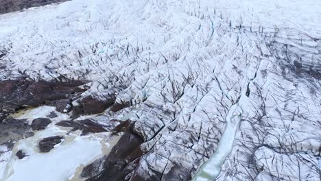 Melting-ice-and-rocks-below-glacier-ice-sheet-in-mountain-valley