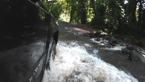 voiture roulant dans l'eau sur une route goudronnée inondée dans la jungle hawaïenne, ralenti