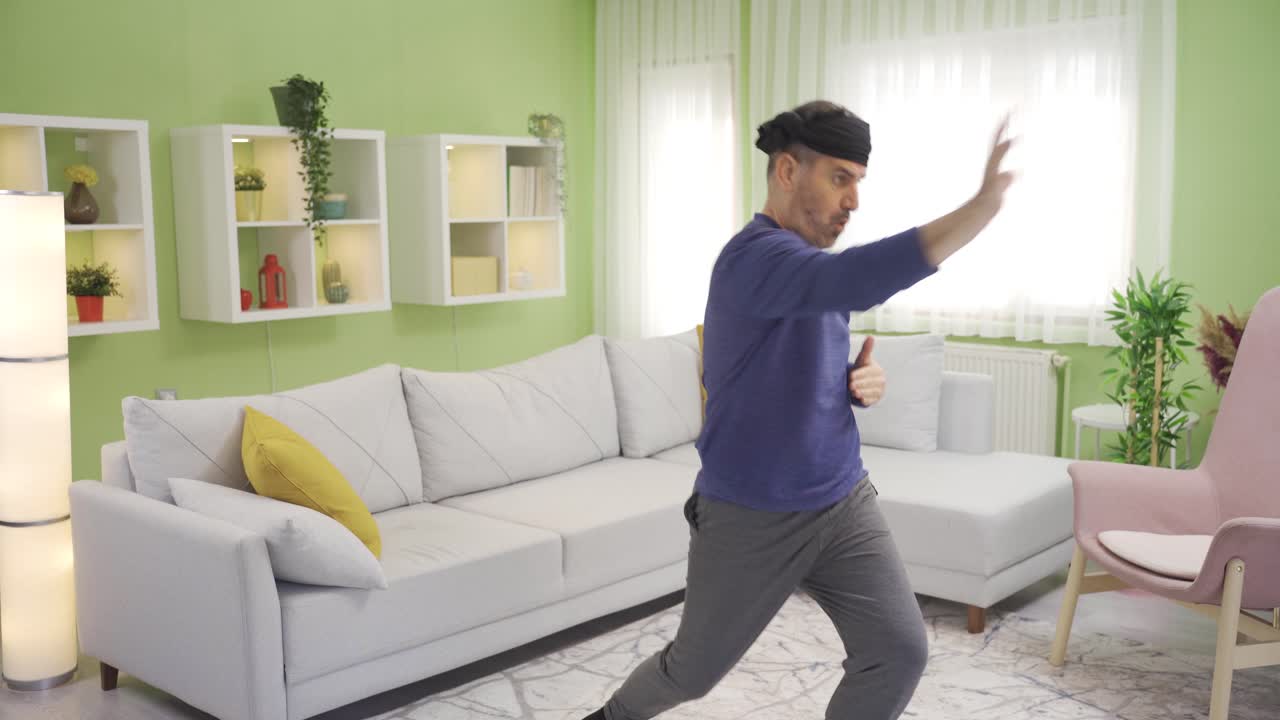 Funny old man doing sports alone at home and getting tired.