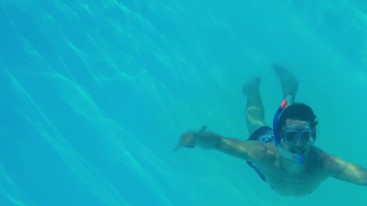 Uomo felice che si tuffa in piscina con la maschera da snorkeling