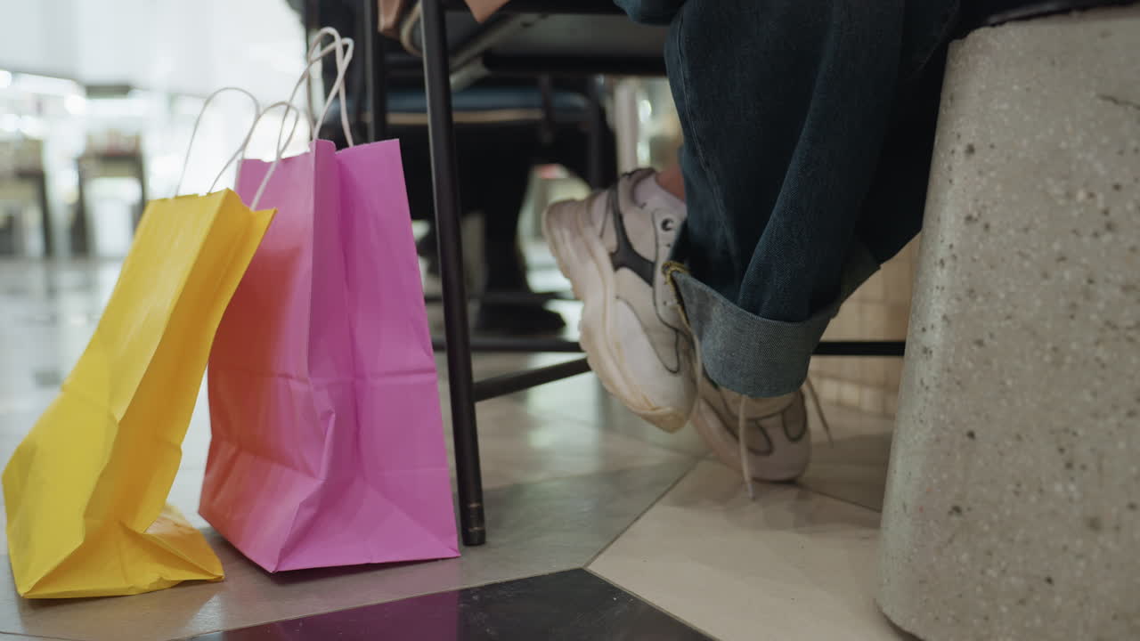 다채로운 액세서리, 다양한 가방과 밝은 신발이 있는 활기 넘치는 마켓플레이스, 다양한 밝은 신발과 액세서리 속에서 편안하게 쇼핑하는 사람들이 보이는 다채로운 리테일 환경 속 평범한 구매자