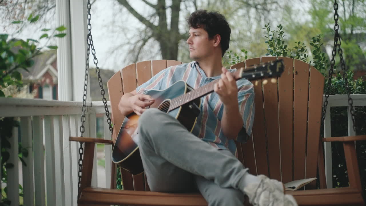 Man Playing Guitar on a Porch Swing