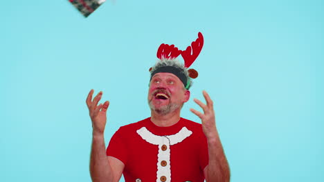 Cheerful-man-in-t-shirt-Santa-Christmas-hat-getting-present-gift-box,-expressing-amazement-happiness