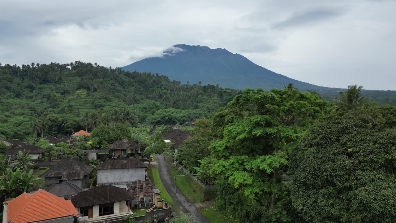 árboles tropicales que conducen hacia el monte agung en una mañana nublada en bali, indonesia