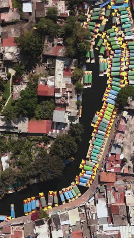 Vista-Vertical-De-Drones-De-Xochimilco-Con-Sus-Trajineras-Deslizándose-Por-Canales