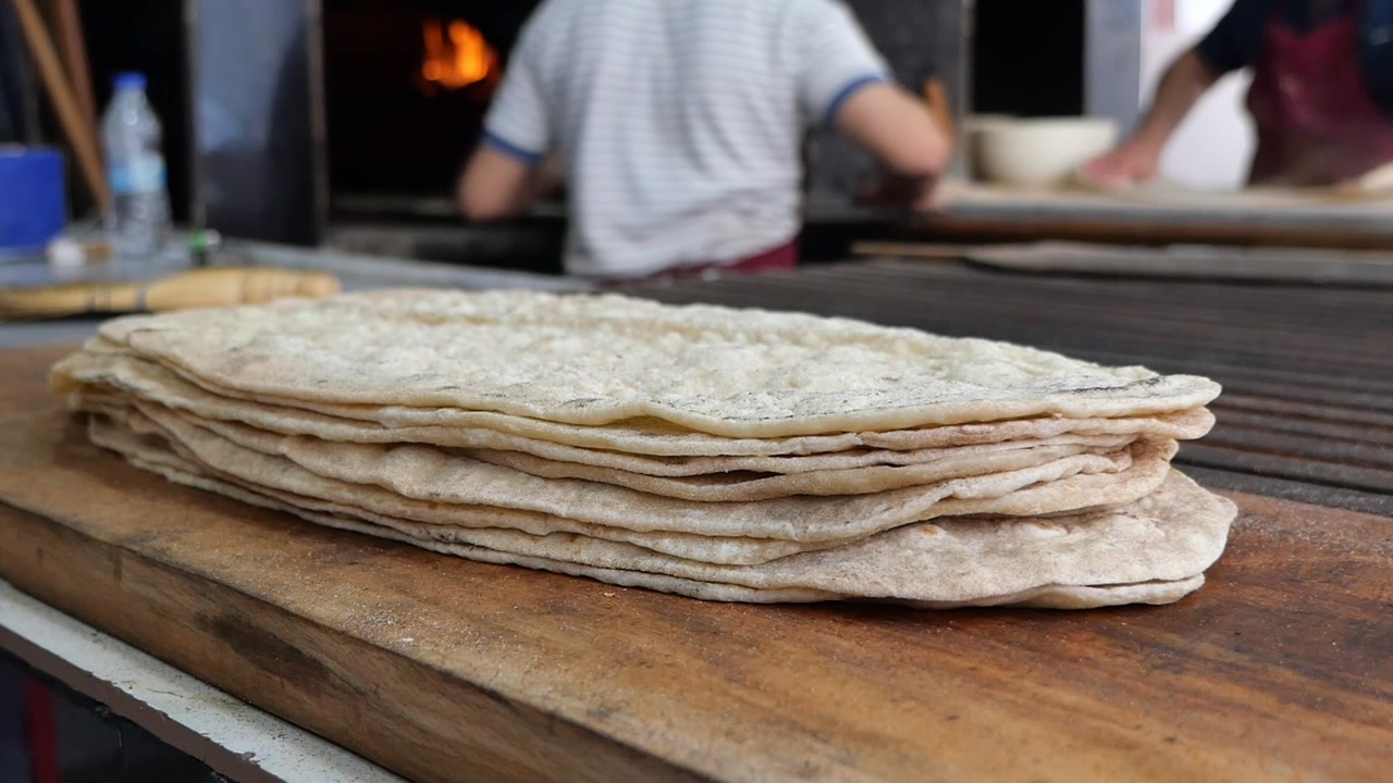 Stack of Freshly Baked Flatbreads on a Wooden Board