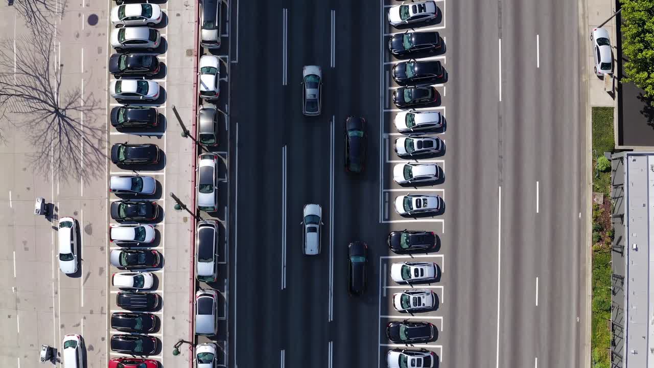 Aerial overhead roadway revealing dense LA highway traffic, multiple lanes filled with vehicles, parking areas framing metropolitan transportation landscape