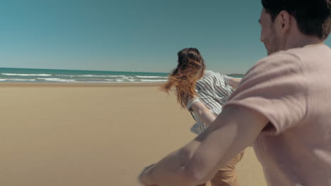 una pareja feliz y enamorada corriendo por la playa.