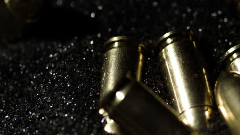 macro detail shot of 9×19mm parabellum bullets sitting on gunpowder dust