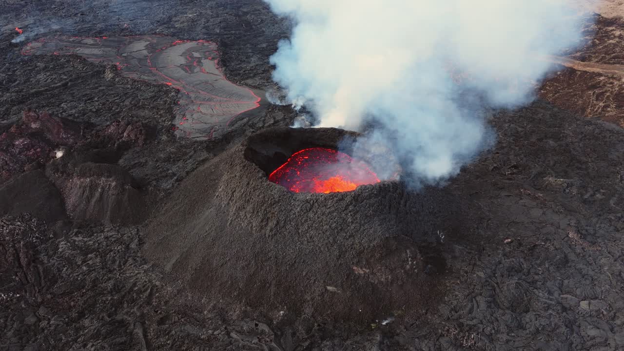 Lava incandescente rossa fiammeggiante in un cratere vulcanico fumante ed eruttivo in Islanda.
