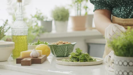 Anonyme-Frau-Zerreißt-Beim-Kochen-In-Der-Küche-Grüne-Basilikumblätter