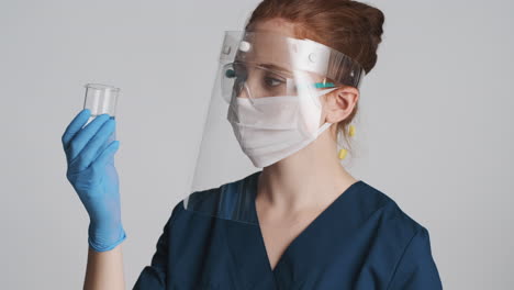 redheaded doctor in front of camera on gray background.