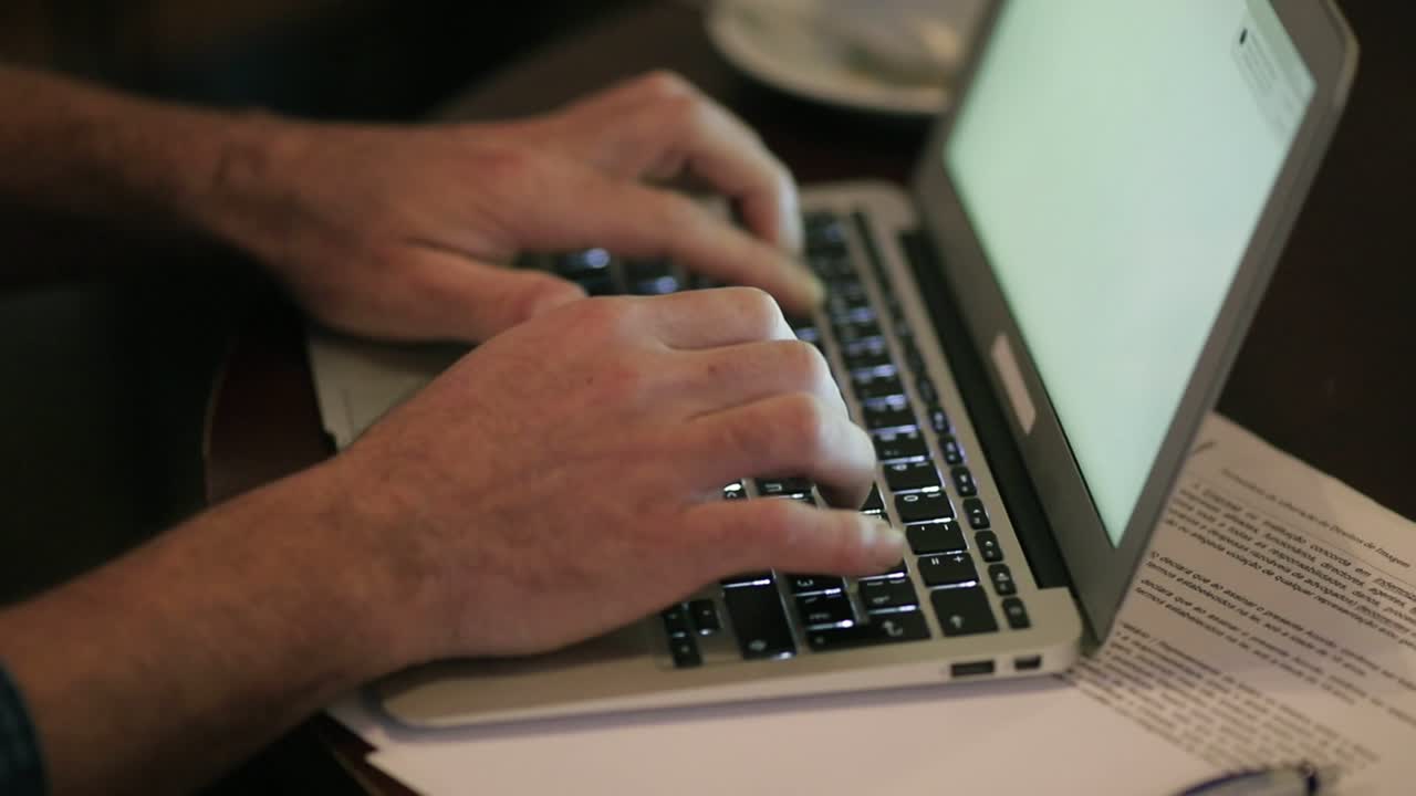 Male hands typing on laptop computer keyboard