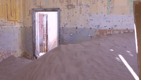 la arena sopla a través de un edificio abandonado en la ciudad fantasma de minería de gemas de kolmanskop namibia 1