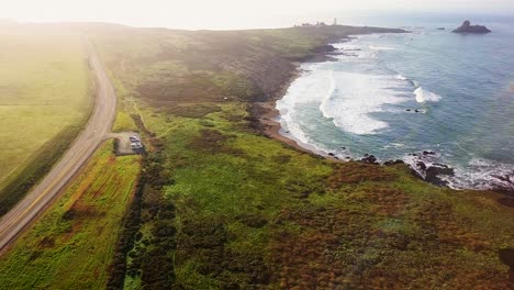 Aerial-reveal-of-beach-and-highway-at-Peidras-Blancas-Lighthouse-in-California