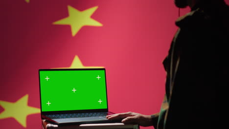 el agente de la policía secreta china usa herramientas de propaganda masiva en la computadora portátil de chrome key