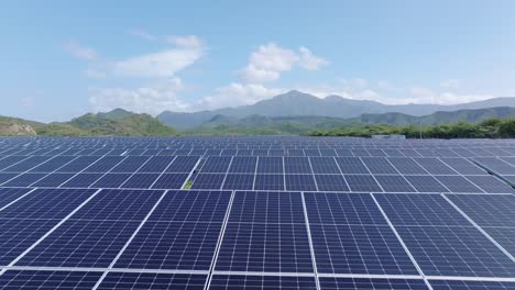 Drone-dolly-forward-over-vast-solar-farm-PV-panels-in-Bani,-Dominican-Republic